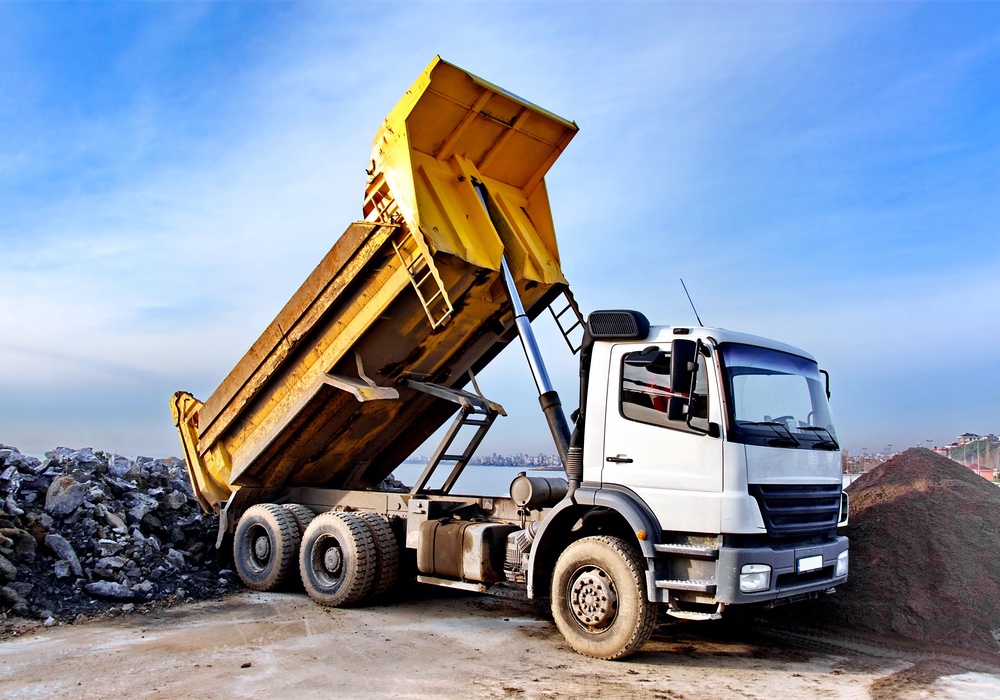A,Dump,Truck,Is,Dumping,Gravel,On,An,Excavation,Site
